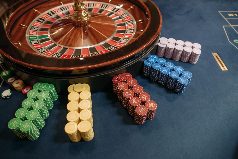 Meja roulette dengan tumpukan chip kasino warna-warni