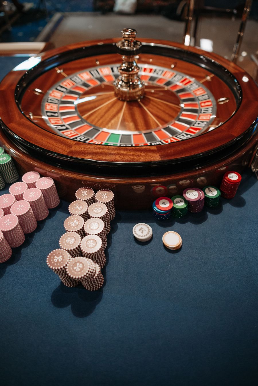 Roda roulette dan tumpukan chip di meja kasino
