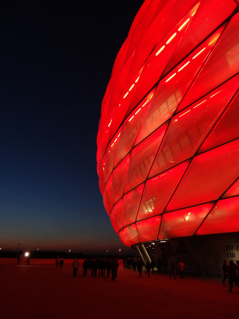 Stadion sepak bola dengan lampu sorot menyala saat pertandingan malam